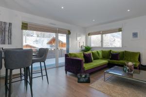 a living room with a green couch and a table at La Niche in Brides-les-Bains