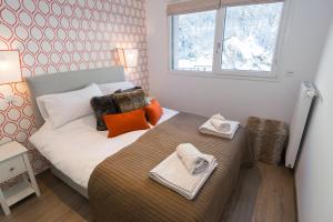 a bedroom with a bed with two towels on it at La Niche in Brides-les-Bains