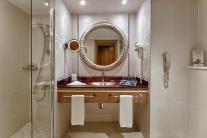 a bathroom with a sink and a shower with a mirror at NG Afyon Wellness & Convention in Afyon