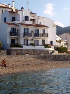 ein Gebäude am Ufer eines Strandes neben dem Wasser in der Unterkunft Lemos Hotel in Kokkari