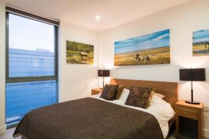 a bedroom with a bed and two paintings on the wall at Trendy Islington flat for 2 with patio in London