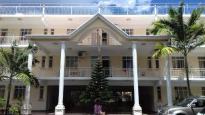 a christmas tree in front of a large building at Alpha Villa in Flic-en-Flac