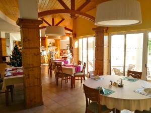 une salle à manger avec tables, chaises et fenêtres dans l'établissement Club House CVL, à Luz