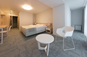 a hotel room with a bed and a table and chairs at Volga Hotel in Kostroma