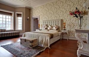 a bedroom with a large bed and a vase of flowers at Talayar Valley Bungalow in Idukki