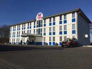 a building with a car parked in front of it at Motel 44 in Geseke