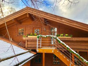 a log cabin with a staircase in front of it at Landhaus de Gaspary in Seehausen am Staffelsee