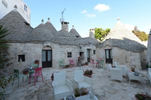 a courtyard of an old house with chairs and tables at Giardino Dei Trulli in Alberobello
