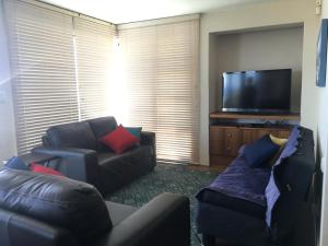 a living room with two couches and a flat screen tv at Royal Albatros in Gansbaai