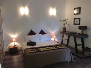 ein Schlafzimmer mit einem Bett und zwei Lampen an der Wand in der Unterkunft Villa Deluy in Saint-Paul