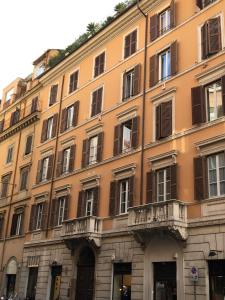 un gran edificio naranja con ventanas y balcones en Viadelloca35, en Roma