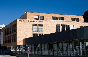 a brick building with a sign on the front of it at Pepis Skihotel in Sankt Anton am Arlberg