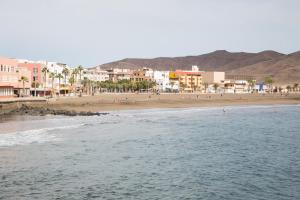 a beach with a group of people in the water at Apartamento con ascensor Gran Tarajal Playa in Gran Tarajal