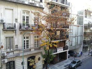 a building with balconies and a car on a city street at Recoleta Apartamento in Buenos Aires