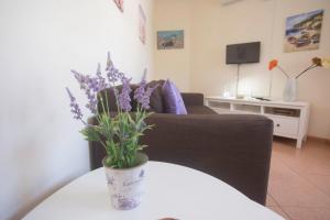 a living room with a couch and a vase with purple flowers at Apartamento con ascensor en primera línea in Gran Tarajal