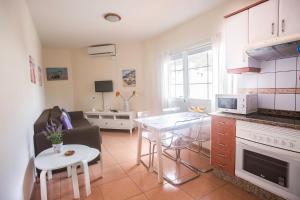 a kitchen and living room with a couch and a table at Apartamento con ascensor en primera línea in Gran Tarajal