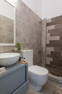 a bathroom with a white toilet and a sink at Kaerati Apartments in Katapola