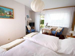 a large white bed in a room with a table and chairs at Ferienwohnung Nain in Bad Dürrheim