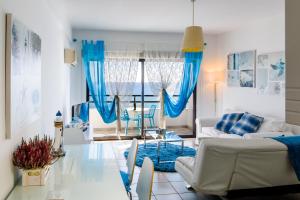 a living room with blue curtains and a couch at Krasas Beach Apts in Larnaca