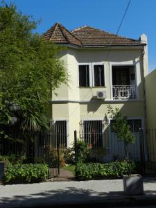 ein weißes Haus mit einem Zaun davor in der Unterkunft B&B Polo in Buenos Aires
