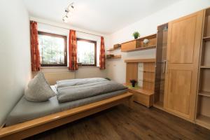 - une petite chambre avec un lit et quelques fenêtres dans l'établissement Appartement Lasshofer, à Mauterndorf