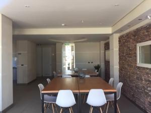 a dining room with a brick wall and a table and chairs at Departamento Marina Horizonte II in Coquimbo