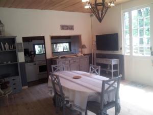 a dining room with a table and a tv at La Palombière, plage à 150m in Meschers-sur-Gironde