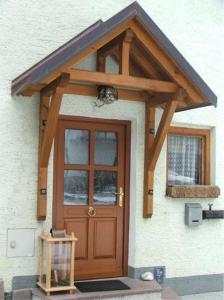 eine Holztür an einem Haus mit einem Fenster in der Unterkunft Haus Pilz in Obertraun