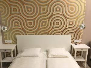 a bedroom with two beds and a wall with a swirl pattern at PrimeQ CityCenter Apartments in Budapest