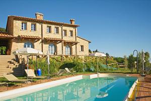 una casa con piscina di fronte a una casa di Borgo in Chianni a Chianni