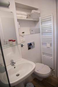 a white bathroom with a toilet and a sink at SMP Apartment 2 in Timişoara