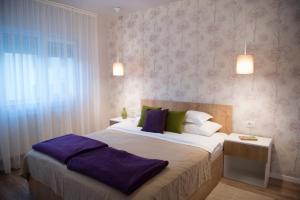 a bedroom with a large bed with purple pillows at SMP Apartment 2 in Timişoara