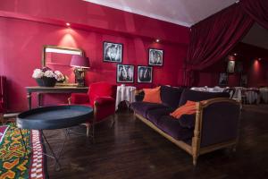 sala de estar con paredes rojas, sofá y mesa en Hôtel du Palais, en Angulema