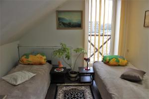 two beds sitting in a room with a window at Gyvenamųjų patalpų nuoma in Kelmė +32 photos