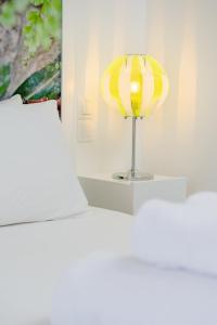 
a white lamp sitting on top of a white bed at Kaerati Apartments in Katapola
