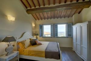 una camera da letto con un letto e due finestre di Borgo in Chianni a Chianni