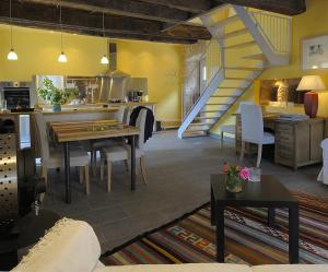 uma cozinha e sala de estar com uma mesa e uma escada em Gite de la Cascade em Salles-la-Source
