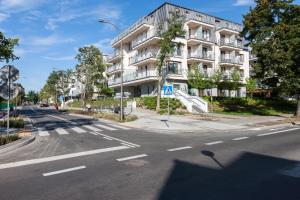 pusta ulica przed dużym białym budynkiem w obiekcie Apartamenty Aquamarina by Noclegi Renters w Świnoujściu +35 zdjęć
