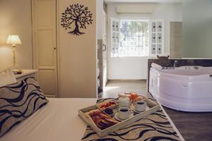 een badkamer met een dienblad met eten en een bad bij Villa Toscana Boutique Hotel -Adults Only in Punta del Este