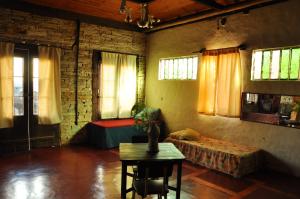 a room with a bed and a table and a couch at Chalé de Pedra - Hospedaria in São Thomé das Letras