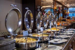 uma linha de buffet com pratos de comida numa mesa em TRYP by Wyndham Guayaquil Airport em Guayaquil