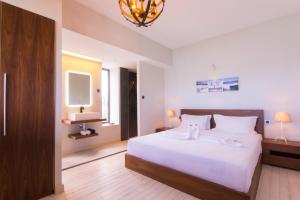 a bedroom with a large white bed and a television at Azure Beach Boutique Hotel in Grand Baie