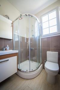 Un baño con ducha, inodoro y ventana. en Villa Daria, en Kyrenia