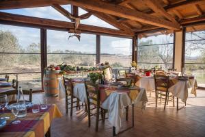 una sala da pranzo con tavoli, sedie e ampie finestre di El Molino a Fonteblanda