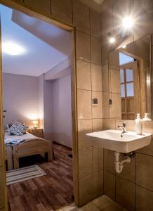 a bathroom with a sink and a bedroom with a bed at Osada Groń in Groń