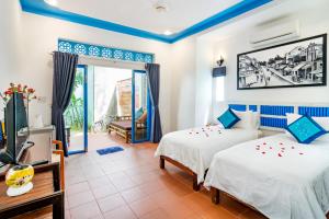 um quarto com duas camas e uma televisão em Local Beach Homestay em Hoi An