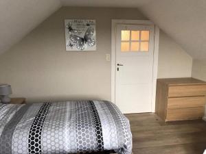 a bedroom with a bed and a white door at Villa Fernley in De Panne