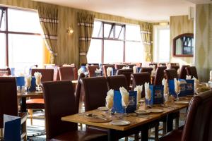 uma sala de jantar com mesas, cadeiras e janelas em Viking Hotel - Adults Only em Blackpool