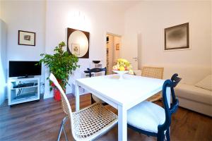 sala de estar con mesa blanca y sillas en Vetrina Holidays Apartment Navona, en Roma