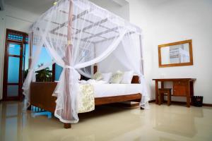 una camera da letto con un letto a baldacchino di BV Residence a Tangalle